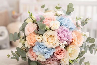 Soft pastel new baby bouquet with seasonal flowers and eucalyptus