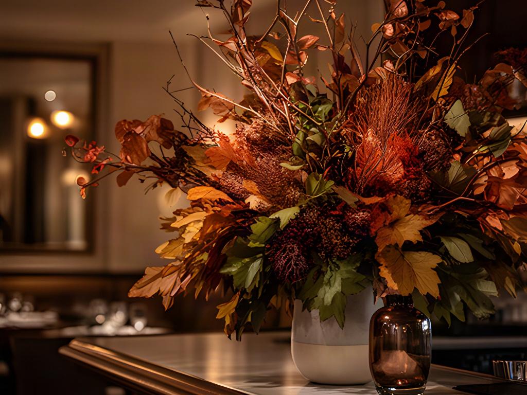 Warm autumn foliage arrangement on a restaurant bar with copper and amber tones